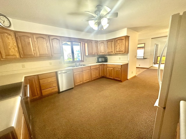 kitchen with stainless steel dishwasher, black microwave, carpet, a sink, and light countertops