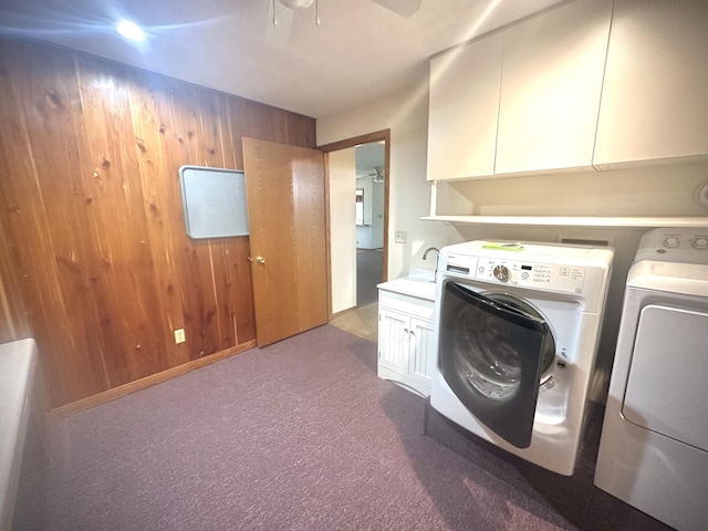 laundry room with separate washer and dryer, cabinet space, a ceiling fan, carpet floors, and wood walls