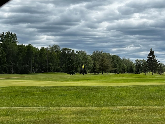 surrounding community featuring a yard and view of golf course