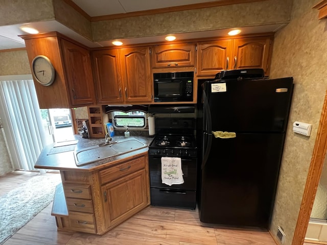 F6LOT139 Pathfinder Vlg, Clover Twp, MN 55037 - kitchen featuring black appliances, a sink, brown cabinets, ornamental molding, and light wood-style flooring