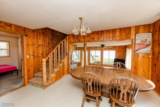 20850 Leona Beach Rd, Erie Twp, MN 56578 - dining room with plenty of natural light, wood walls, a chandelier, stairway, and carpet flooring