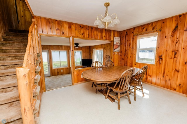 20850 Leona Beach Rd, Erie Twp, MN 56578 - dining room featuring stairway, healthy amount of natural light, wooden walls, a chandelier, and baseboards