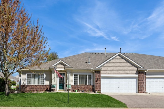 view of front of property featuring brick siding, a front lawn, asphalt driveway, a garage, and roof with shingles