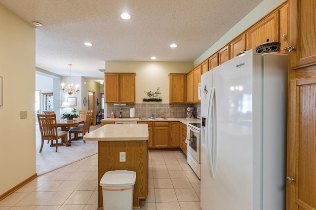 kitchen with white appliances, light countertops, a chandelier, a sink, and a textured ceiling