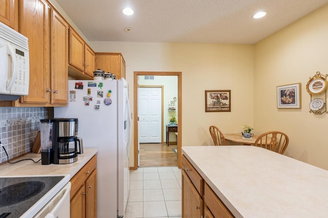 kitchen featuring white appliances, light countertops, backsplash, recessed lighting, and light tile patterned floors