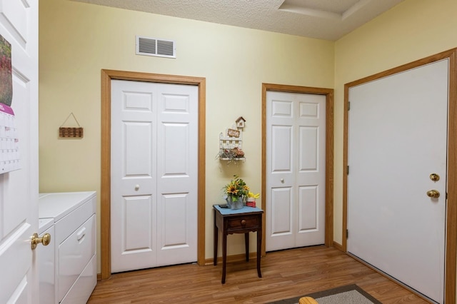 foyer featuring independent washer and dryer and light wood finished floors