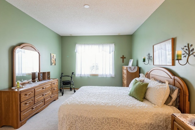 bedroom featuring light carpet and a textured ceiling