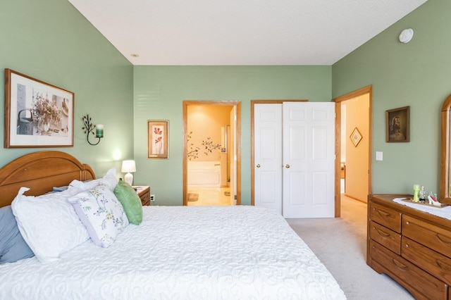 bedroom featuring light carpet and connected bathroom