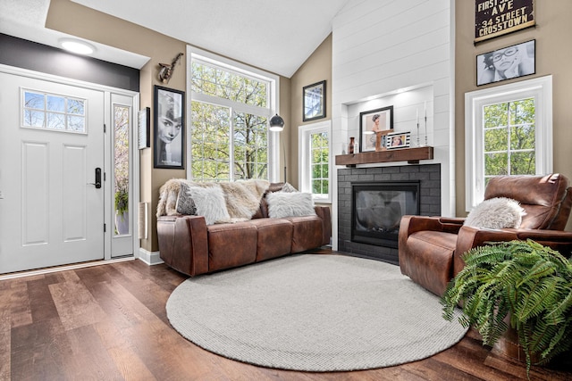 living room with high vaulted ceiling, dark wood-style floors, a fireplace, plenty of natural light, and baseboards