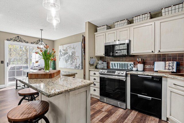 kitchen featuring appliances with stainless steel finishes, dark wood finished floors, a kitchen island, decorative backsplash, and pendant lighting