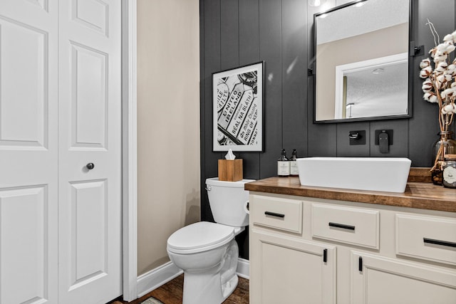 bathroom featuring vanity, toilet, and baseboards