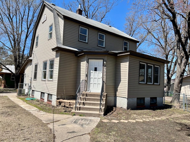 view of front of home with entry steps, fence, a chimney, and cooling unit