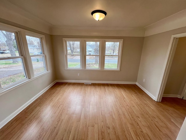 unfurnished room with baseboards and light wood-type flooring