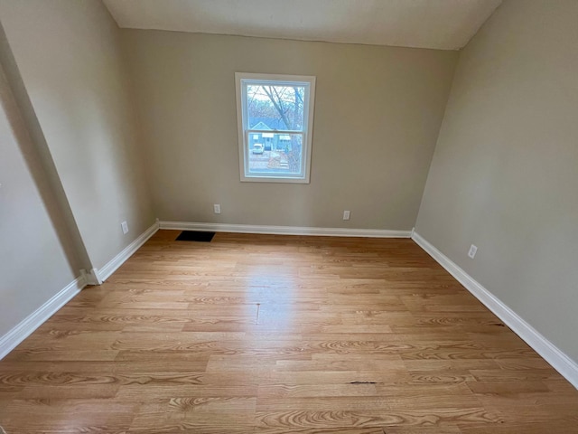 empty room with light wood-type flooring and baseboards