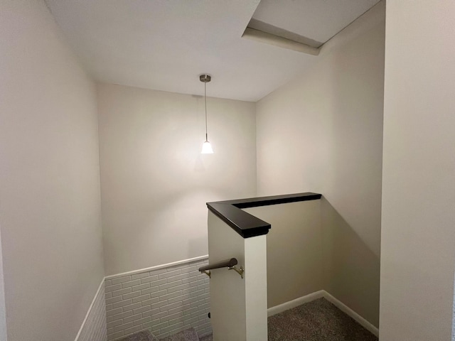 staircase featuring carpet and baseboards