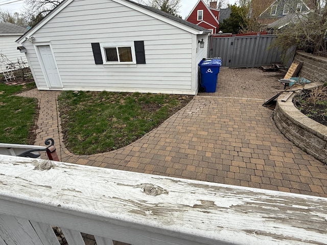 view of property exterior with a patio area, fence, and a gate