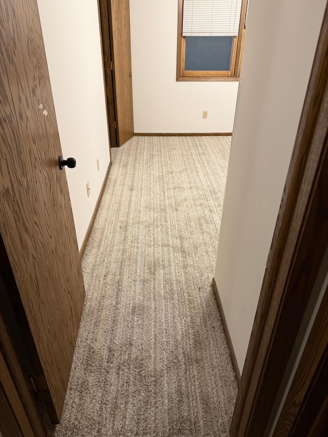 empty room featuring carpet flooring and baseboards