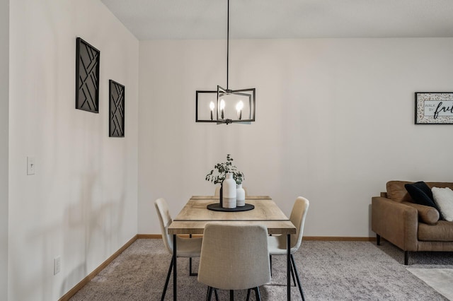 dining room featuring a chandelier, carpet, and baseboards