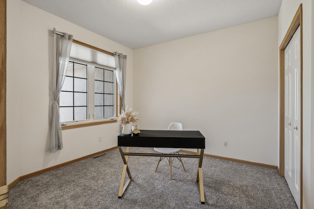 carpeted office with baseboards and a textured ceiling