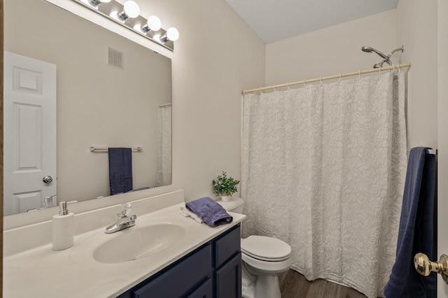 full bathroom with toilet, wood finished floors, and vanity