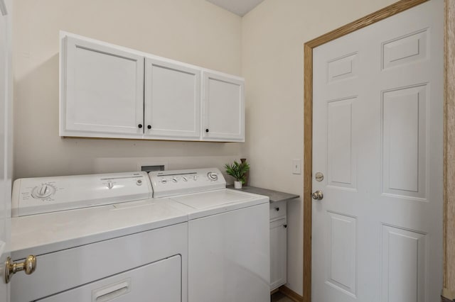 clothes washing area featuring separate washer and dryer and cabinet space