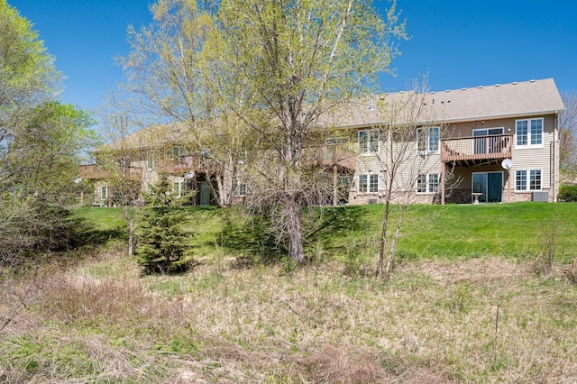 back of house with a wooden deck and a lawn