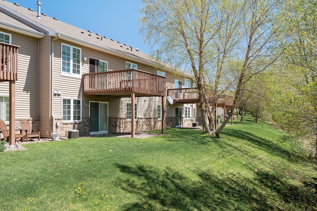 back of house with a lawn, a deck, and central air condition unit
