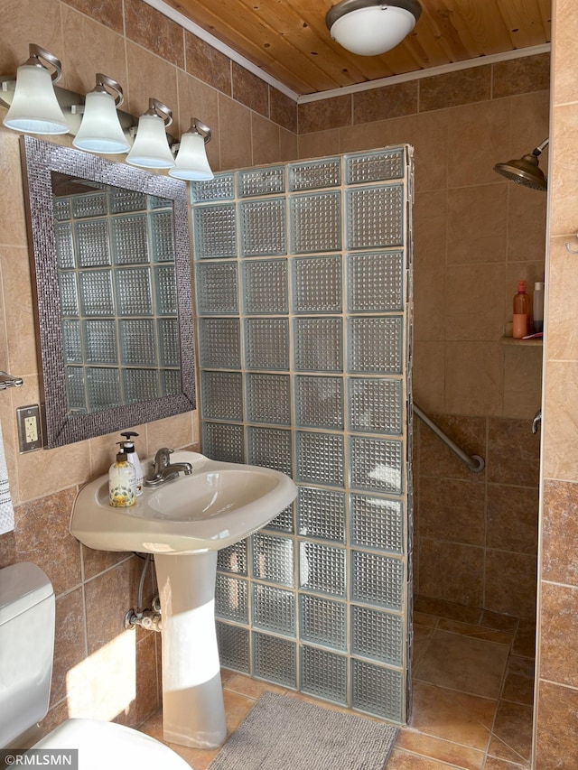 bathroom featuring a walk in shower, wood ceiling, toilet, tile walls, and tile patterned floors