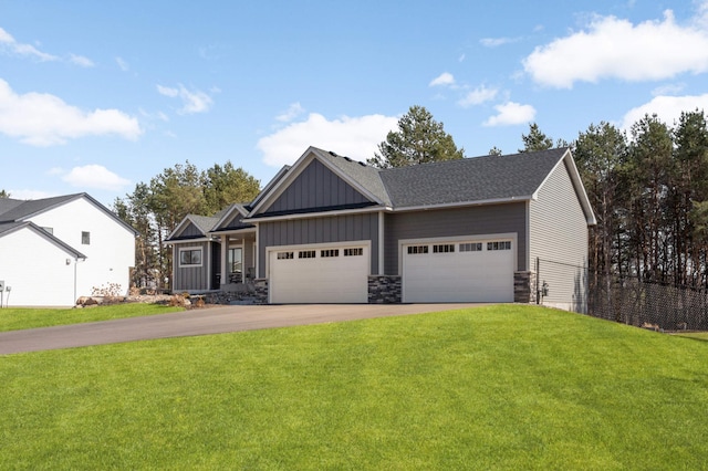 15359 Quamba St NE, Ham Lake, MN 55304 - craftsman-style house featuring board and batten siding, asphalt driveway, an attached garage, a front lawn, and stone siding