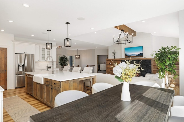 15359 Quamba St NE, Ham Lake, MN 55304 - kitchen featuring stainless steel appliances, open floor plan, light wood-style flooring, glass insert cabinets, and a large island