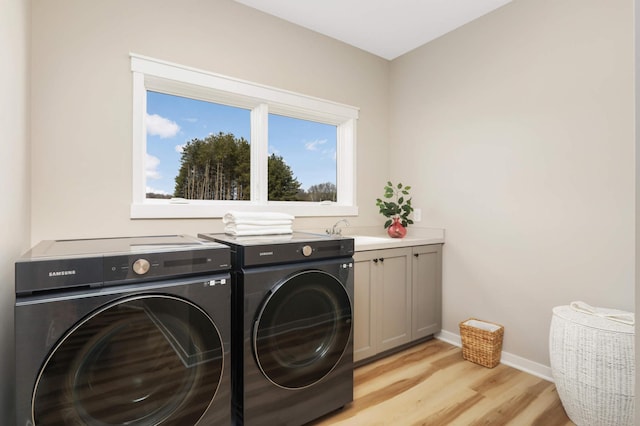 15359 Quamba St NE, Ham Lake, MN 55304 - washroom with washing machine and clothes dryer, cabinet space, light wood-style flooring, and baseboards