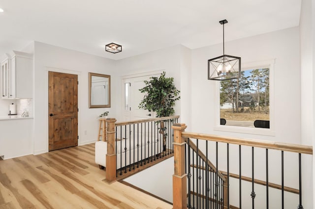 15359 Quamba St NE, Ham Lake, MN 55304 - hallway featuring light wood finished floors, an upstairs landing, and a chandelier