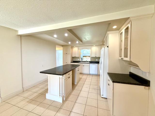421 Main St E, Eitzen, MN 55931 - kitchen featuring white appliances, recessed lighting, a kitchen island, light tile patterned floors, and dark countertops