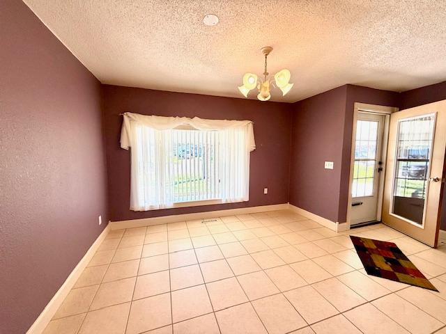 421 Main St E, Eitzen, MN 55931 - empty room featuring a textured ceiling, a chandelier, light tile patterned floors, and baseboards