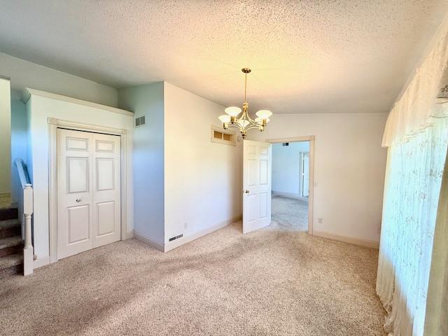 421 Main St E, Eitzen, MN 55931 - unfurnished dining area with a chandelier, light carpet, and a textured ceiling