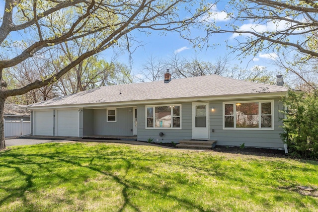 single story home featuring an attached garage, a chimney, asphalt driveway, and a front lawn