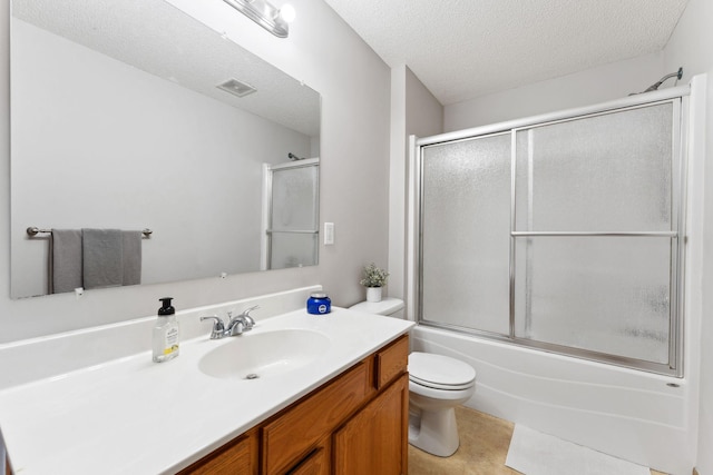 bathroom featuring a textured ceiling, toilet, vanity, enclosed tub / shower combo, and tile patterned floors
