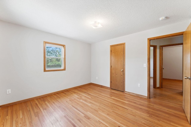 unfurnished bedroom with light wood-style floors, baseboards, and a closet