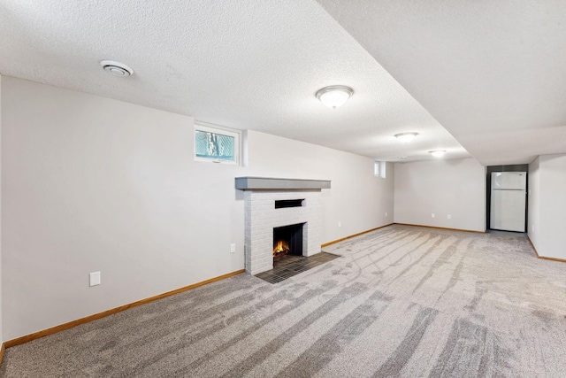 unfurnished living room with baseboards, a fireplace, carpet, and a textured ceiling