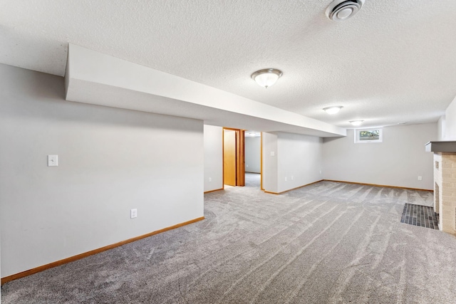 below grade area featuring carpet floors, baseboards, and a textured ceiling