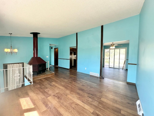 4806 Monroe St NE, Columbia Heights, MN 55421 - unfurnished living room featuring a chandelier, a textured ceiling, wood finished floors, ceiling fan, and a wood stove