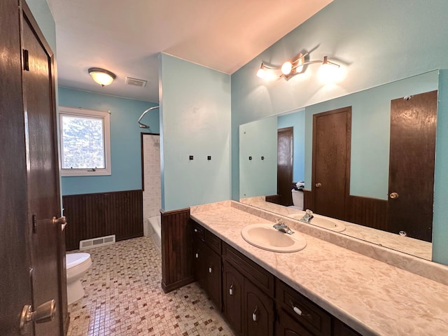 4806 Monroe St NE, Columbia Heights, MN 55421 - bathroom with a wainscoted wall, toilet, vanity, shower / washtub combination, and tile patterned floors