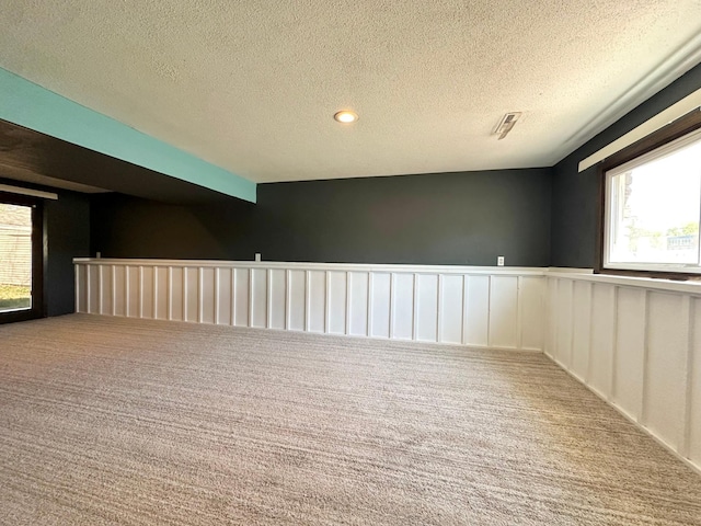 4806 Monroe St NE, Columbia Heights, MN 55421 - carpeted empty room featuring wainscoting, healthy amount of natural light, and a textured ceiling