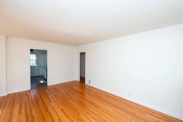 unfurnished room with light wood finished floors and baseboards