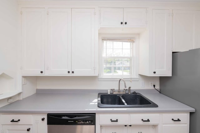 kitchen featuring stainless steel appliances, a sink, light countertops, and white cabinets