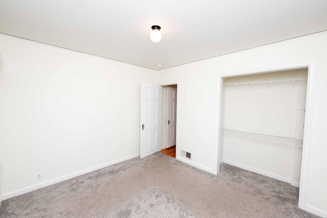 unfurnished bedroom featuring carpet, baseboards, and a closet