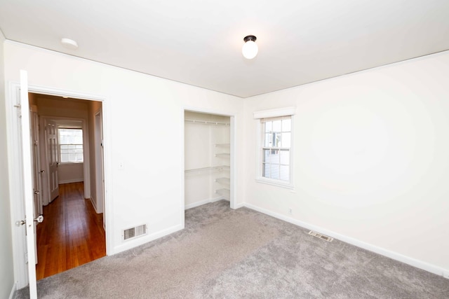 unfurnished bedroom with carpet floors, baseboards, and multiple windows