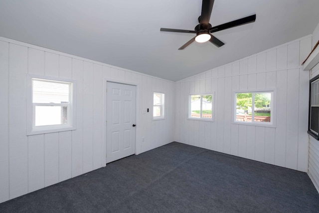 unfurnished room with dark colored carpet, ceiling fan, and lofted ceiling