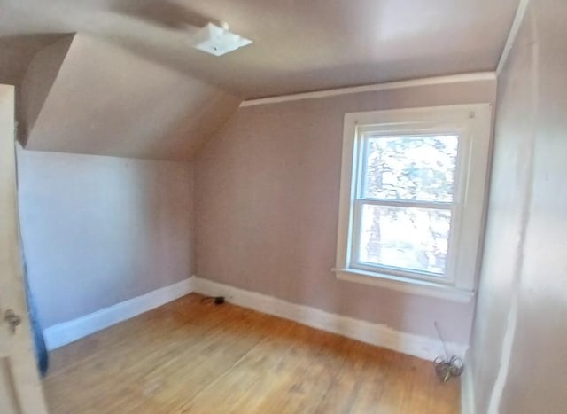 bonus room featuring baseboards, light wood-style flooring, and lofted ceiling