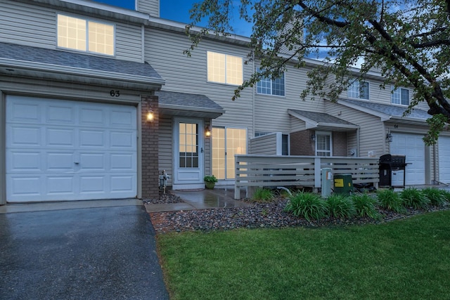 13210 Meadowood Trl NW Unit 63Nw, Coon Rapids, MN 55448 - view of property with asphalt driveway, a chimney, a front yard, brick siding, and an attached garage